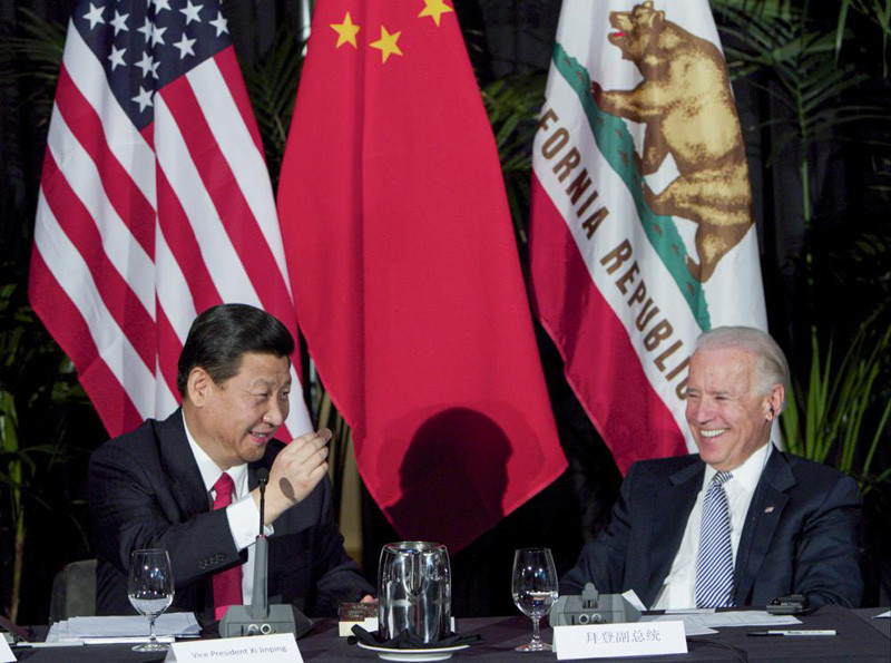 Xi Jinping, China's president and Communist Party chief, left, eats a Hawaiian macadamia chocolate gifted by Governor of Hawaii, Neil Abercrombie, not seen, during a governors meeting held inside the Walt Disney Concert Hall as Vice President Joe Biden, right, looks on in Los Angeles., Feb. 17, 2012. As President Joe Biden and Xi Jinping prepare to hold their first summit on Monday, Nov. 15, the increasingly fractured U.S.-China relationship has demonstrated that the ability to connect on a personal level has its limits. Biden nonetheless believes there is value in a face-to-face meeting, even a virtual one like the two leaders will hold Monday evening. (AP File Photo)
