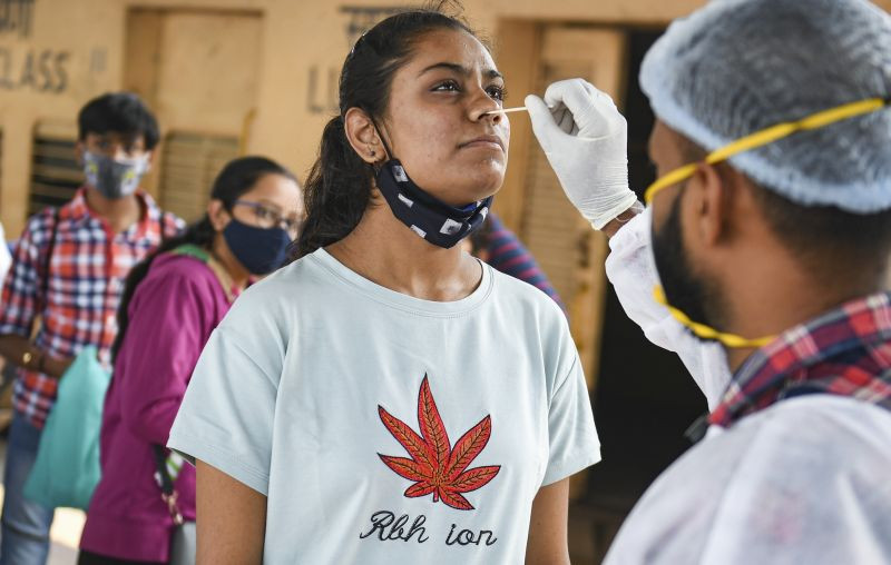 A BMC health worker takes swab sample of an outstation passenger for COVID-19 test, at Dadar railway station in Mumbai on December 7, 2021. (PTI Photo)