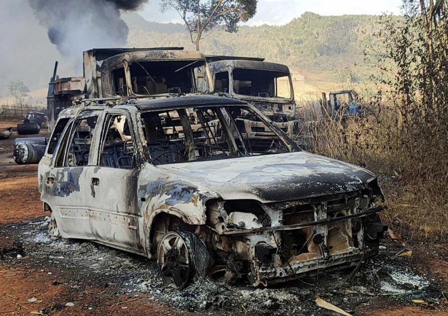 In this photo provided by the Karenni Nationalities Defense Force (KNDF), vehicles smolder in Hpruso township, Kayah state, Myanmar on December 24, 2021. Myanmar government troops rounded up villagers, some believed to be women and children, fatally shot more than 30 and set the bodies on fire, a witness and other reports said Saturday. (AP File Photo)