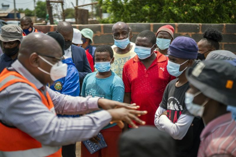 Residents listen to Gauteng Province Premier David Makhura in Lawley, South Africa, Friday Dec. 3, 2021 for the launch of the Vooma vaccination program against COVID-19. South Africa has accelerated its vaccination campaign a week after the discovery of the omicron variant of the coronavirus. (AP Photo)