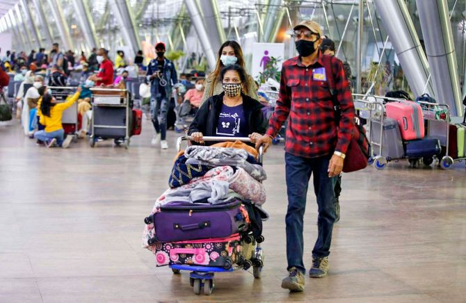 Passengers wearing face mask come out from Sardar Vallabhbhai Patel International airport amid concern over 'Omicron' variant of coronavirus in Ahmedabad. Photograph: PTI Photo