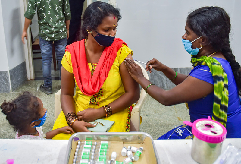 A health worker administers a dose of COVID-19 vaccine to a woman amid fear of spread of a new variant of COVID-19, in Bengaluru on December 3, 2021. (PTI Photo)