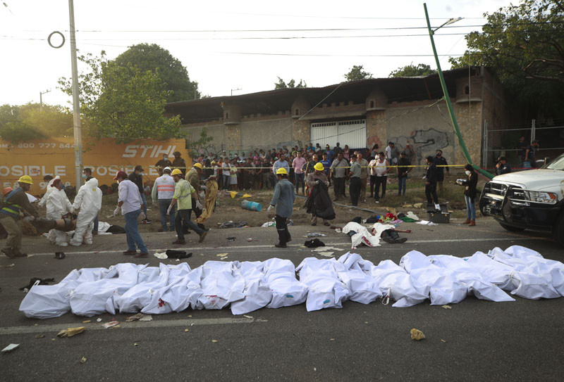 Bodies in bodybags are placed on the side of the road after an accident in Tuxtla Gutierrez, Chiapas state, Mexico, Thursday, Dec. 9, 2021. Mexican authorities say at least 49 people were killed and dozens more injured when a cargo truck carrying Central American migrants rolled over on a highway in southern Mexico.  (AP/PTI Photo)