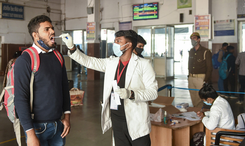A medical worker collects swab sample of a passenger for Covid-19 test amid fear of spread of Omicron varaint, at Charbagh railway station in Lucknow on December 3, 2021. (PTI Photo)