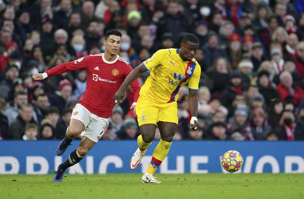 Manchester United's Cristiano Ronaldo, left, challenges for the ball with Crystal Palace's Marc Guehi during the English Premier League soccer match between Manchester United and Crystal Palace at Old Trafford stadium in Manchester, England, Sunday, Dec. 5, 2021. (AP Photo/Jon Super)