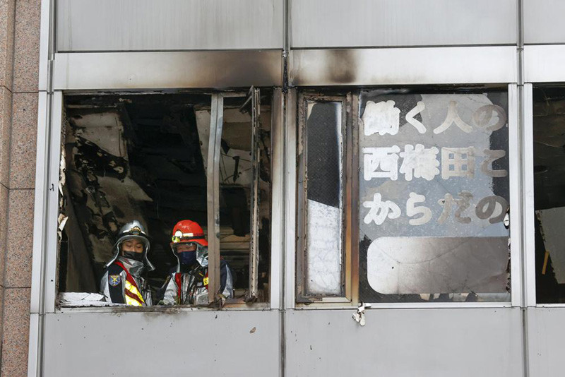 Firefighters stand on a floor at a building where a fire broke out in Osaka, western Japan Friday, Dec. 17, 2021. Japan's NHK says a fire broke out in the building and dozens of people were feared dead. (AP Photo)