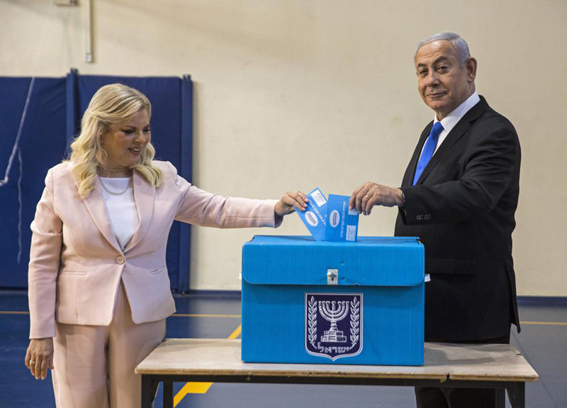 Israeli Prime Minister Benjamin Netanyahu and his wife Sarah casts their votes at a voting station in Jerusalem, Sept. 17, 2019. On Sunday Dec. 12, 2021, an Israeli parliamentary committee voted to stop providing personal security details to former prime minister Benjamin Netanyahu’s wife and adult sons. The decision comes six months after the longtime leader was ousted from power. As opposition leader, he will continue to have a security detail and private driver. (AP File Photo)