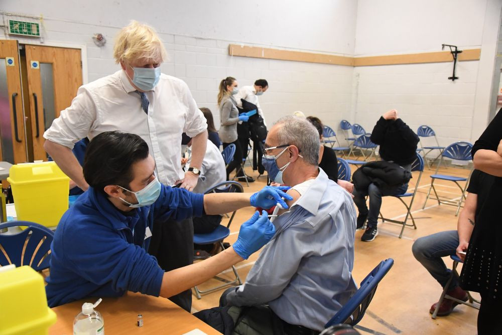 London: British Prime Minister Boris Johnson visits Stow Health Vaccination center, in Westminster, London, Monday, Dec. 13, 2021.  Johnson says that Britain faces a "tidal wave" of infections from the omicron coronavirus variant and he has announced a huge increase in booster vaccinations to strengthen defenses against it. AP/PTI(