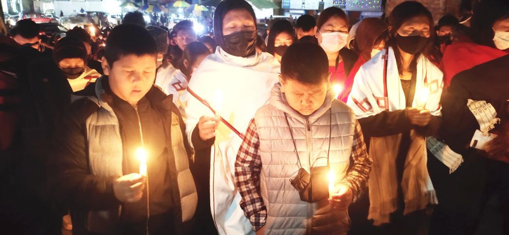 Two children pray with others during the tribute vigil organised by the Konyak Union Kohima in memory of the Oting-Mon victims under the theme, ‘Lest We Forget’  at Old MLA junction, Kohima on December 12. (Morung Photo)
