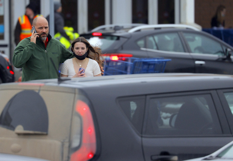 Parents walk away with their kids from the Meijer's parking lot where many students gathered following an active shooter situation at Oxford High School on November 30, 2021, in Oxford, Mich. Police took a suspected shooter into custody and there were multiple victims, the Oakland County Sheriff's office said. (AP/PTI Photo)