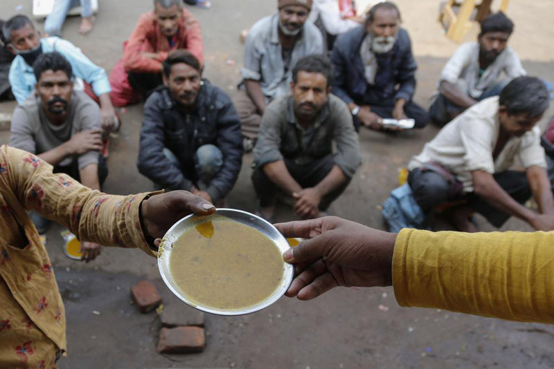 People wait for free food outside an eatery in Ahmedabad, India, Wednesday, Jan. 20, 2021. The prolonged pandemic and surging prices are undermining food security for millions of people in Asia, with 1.8 billion lacking access to healthy diets, a report by the UN’s Food and Agricultural Organization said on December 15, 2021. (AP File Photo)