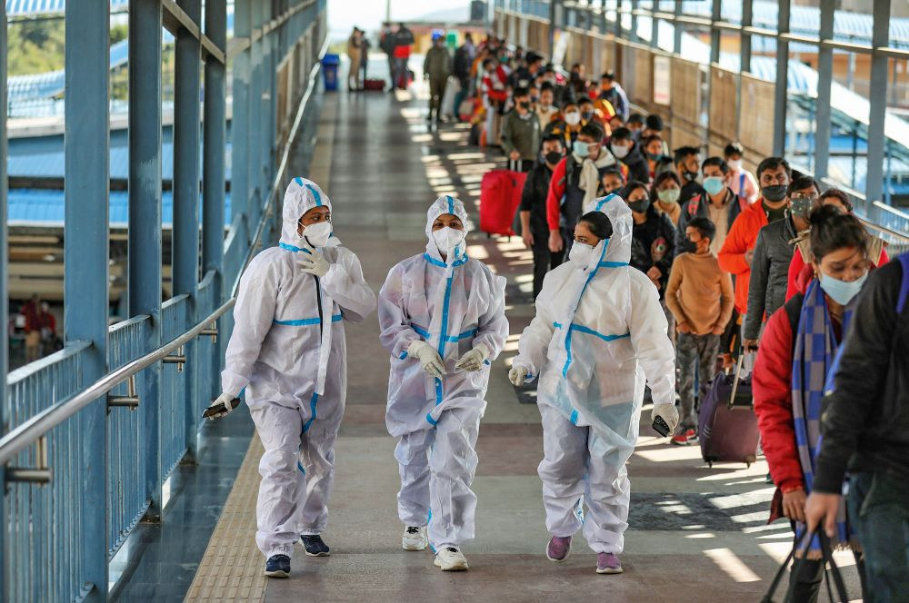 Jammu: Health workers walk past the passengers waiting in a queue during Covid-19 testing at Katra railway station, amid the threat of spreading of the new Covid-19 variant  Omicron , in Jammu, Monday, Dec. 6, 2021. (PTI Photo)