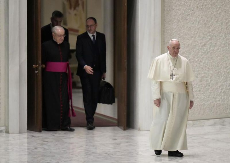 Pope Francis walks to reach his chair as he arrives for his weekly general audience in the Paul VI Hall, at the Vatican, Wednesday, Jan. 26, 2022. (AP Photo)