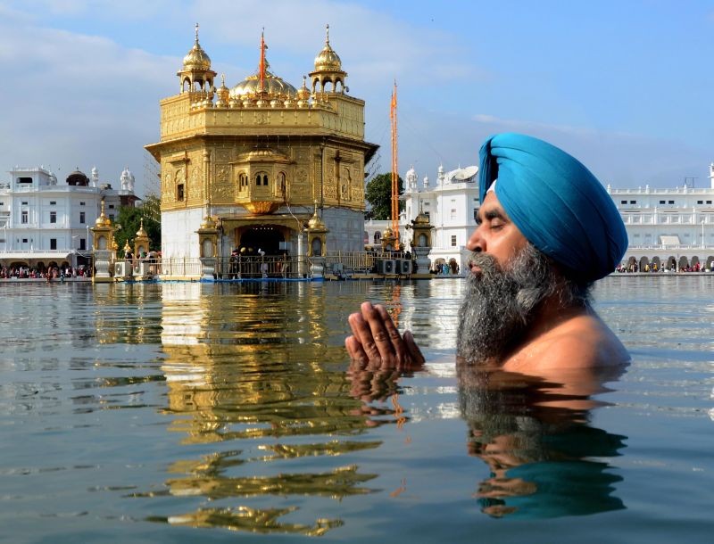 Amritsar: A devotee takes a dip in the holy sarovar (pond) on the occasion of the birth anniversary of the 10th Sikh Guru Gobind Singh, at the Golden Temple in Amritsar, Sunday, January 9, 2022. (PTI Photo)