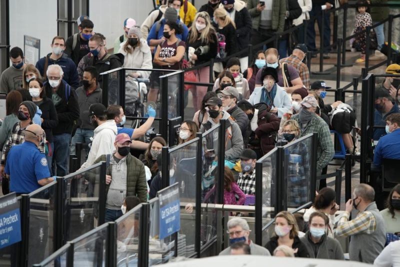 Passengers queue up to pass through the north security checkpoint Monday, Jan. 3, 2022, in the main terminal of Denver International Airport in Denver. (AP Photo)