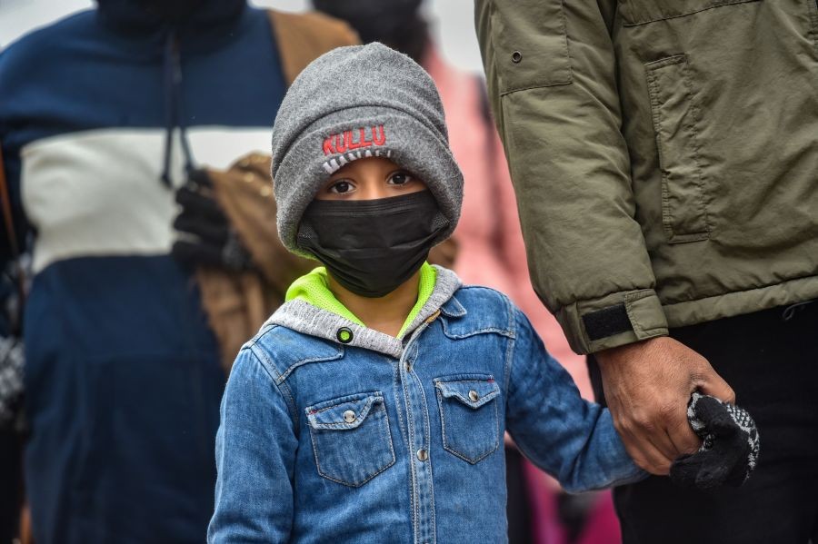 New Delhi: A child wearing a face mask at a crowded market on a cold winter day at Chandni Chowk in Old Delhi, Monday, Jan. 24, 2022. (PTI Photo/Arun Sharma)