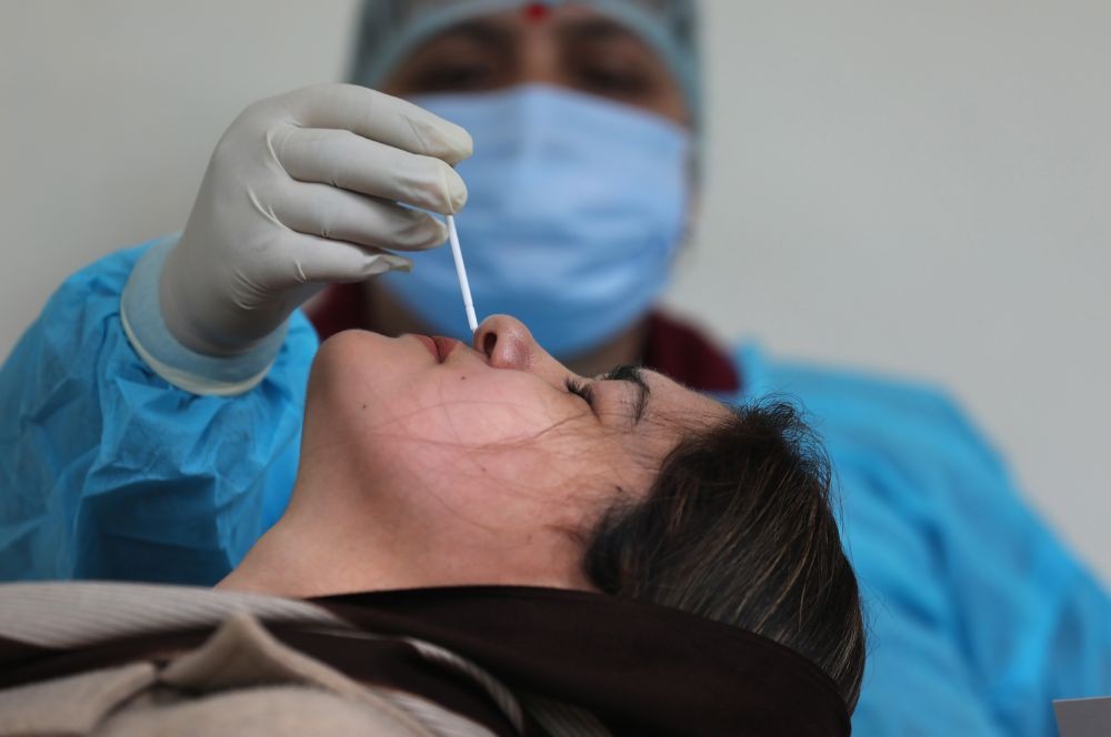 Jammu: A health worker takes swab sample of a woman for COVID-19 test, amid a surge in cases, in Jammu, Friday, Jan 21, 2022. (PTI Photo)