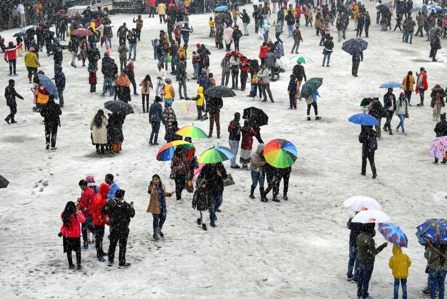 Shimla: Tourist walk on a snow-covered road during snowfall at Ridge in Shimla, Tuesday, Jan. 25, 2022. (PTI Photo)(