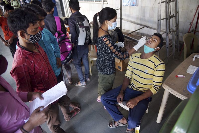 A medic from NMMC Health Department collects swab sample of a man for COVID-19 test, at Nerul railway station in Navi Mumbai on January 29, 2022. (PTI Photo)