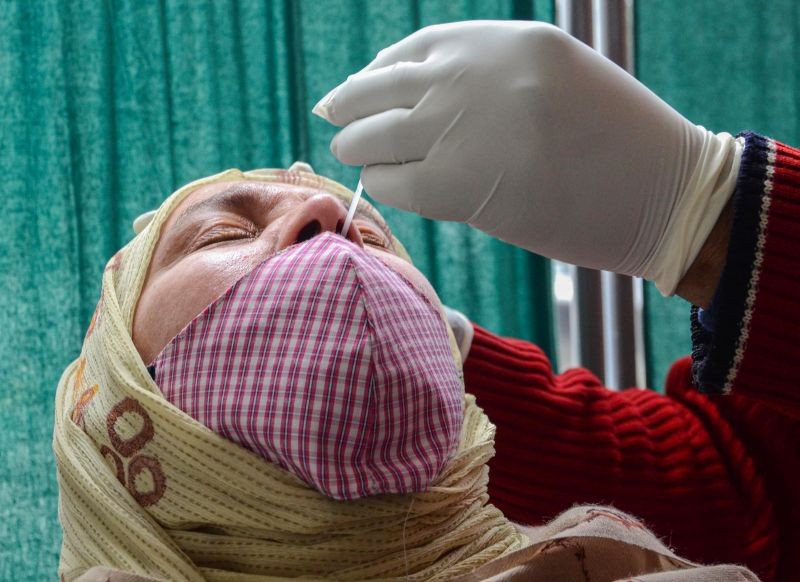 A healthworker collects a nasal swab sample for COVID-19 test at a hospital in Amritsar on January 18, 2022. (PTI Photo)