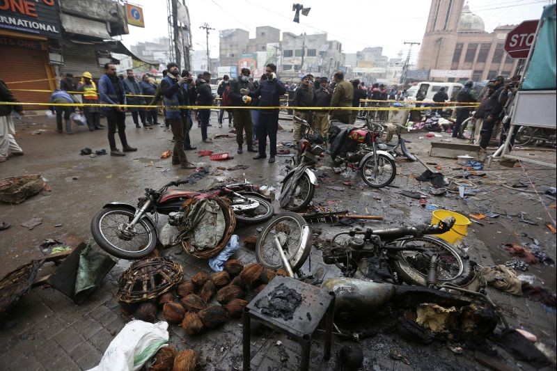 Police officials examine the site of bomb explosion, in Lahore, Pakistan, Thursday, Jan. 20, 2022. Police said the powerful bomb exploded in a crowded bazar in Pakistan's second largest city of Lahore, killing several people and wounding dozens of others. (AP/PTI Photo)