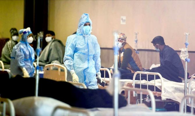 A health worker interacts with COVID-19 patients inside the Shehnai Banquet Hall, a COVID-19 care facility, during the third wave of the coronavirus, in New Delhi, on Wednesday, January 12, 2022. Photograph: Kamal Kishore/PTI Photo