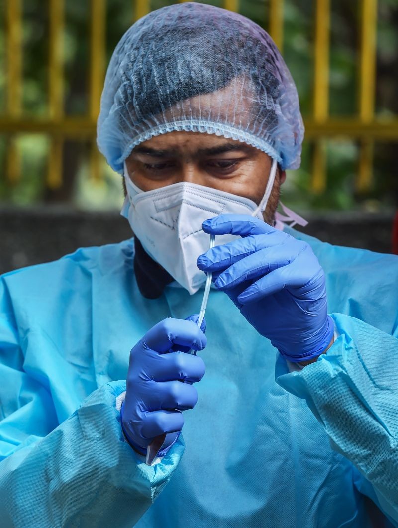 A healthworker collects a swab sample for COVID-19 test  at SDMC Urban Public Health Centre in Daryaganj, New Delhi on January 18, 2022. (PTI Photo)