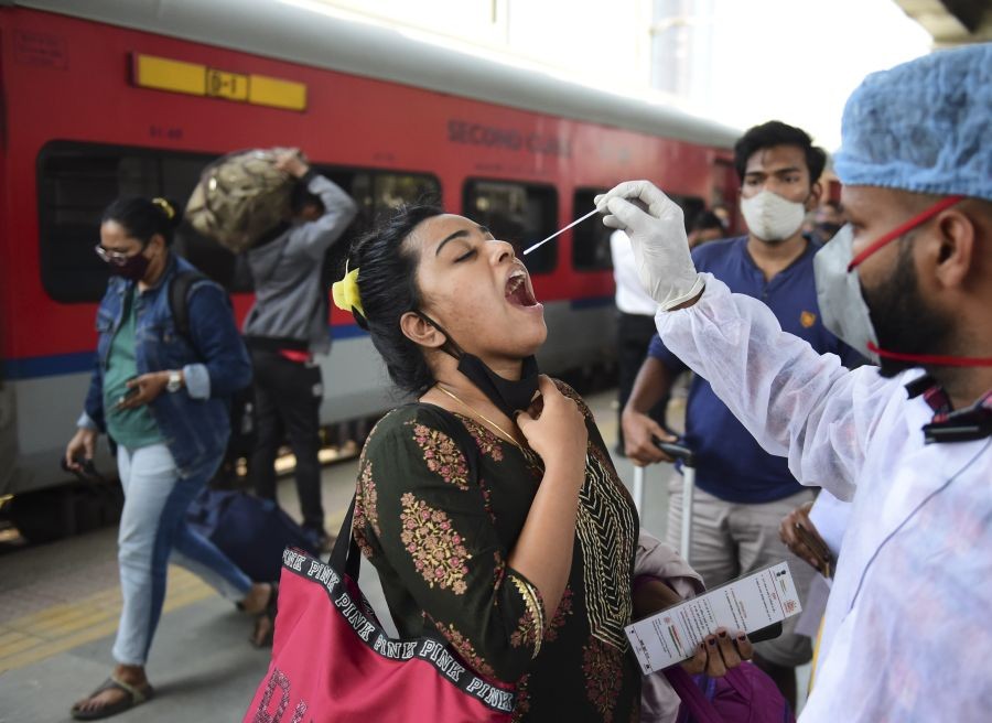 Mumbai: A BMC health worker collects swab sample of an outstation passenger for COVID-19 test, at Dadar railway station in Mumbai, Tuesday, Jan. 18, 2022. (PTI Photo/Shashank Parade)