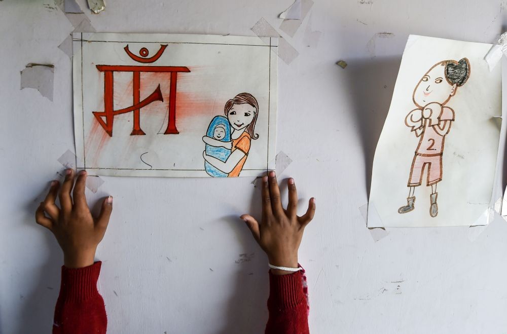 New Delhi: A child sticks a drawing on a wall at a newly renovated creche, at Mandoli Jail in New Delhi, Friday, Feb. 14, 2022. As schools reopened after a long hiatus imposed due to COVID-19, the children lodged in women centric jail no 16 in Mandoli have also joined their newly renovated creche. (PTI Photo/Manvender Vashist)