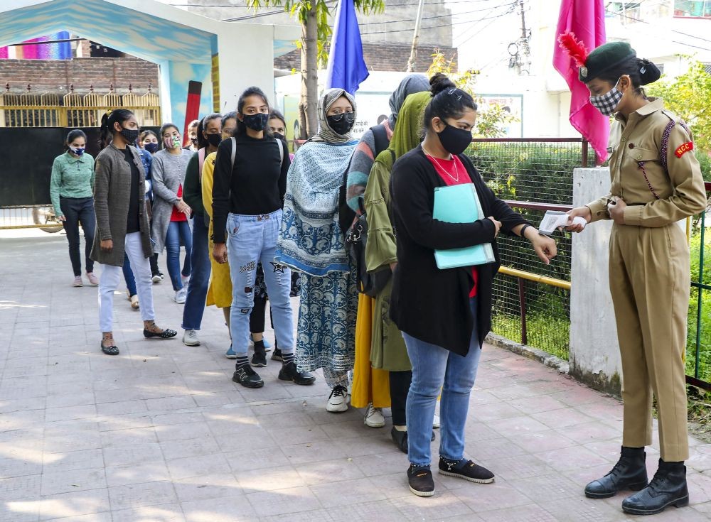 Jammu: Students undergo thermal screening before entering a school to attend class after authorities allowed schools to reopen for IX standard and above in Jammu, Monday, Feb 14, 2022. (PTI Photo)