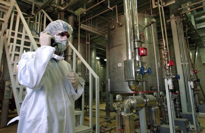 Wearing protective clothes, an Iranian security person, talks in a part of the Uranim Conversion Facility, prior to the arrival of then Iranian President, Mohammad Khatami, just outside the city of Isfahan, Iran, March 30, 2005. While the world’s attention has been focused on Ukraine, the Biden administration also has been racing forward with other global powers toward restoring the 2015 international nuclear deal with Iran. In Feb. 2022, after months of negotiations in Vienna, the various sides have indicated a new deal is close, perhaps in the coming days. (AP File Photo)