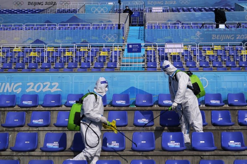 Workers in protective gear disinfects seats following the men's freestyle skiing big air finals of the 2022 Winter Olympics on February 9, 2022, in Beijing.  (AP/PTI Photo)