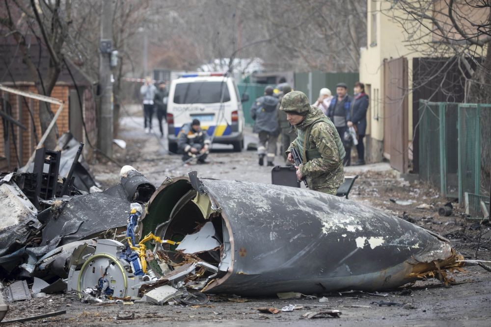 Kyiv : A Ukrainian Army soldier inspects fragments of a downed aircraft in Kyiv, Ukraine, Friday, Feb. 25, 2022. It was unclear what aircraft crashed and what brought it down amid the Russian invasion in Ukraine. Russia is pressing its invasion of Ukraine to the outskirts of the capital after unleashing airstrikes on cities and military bases and sending in troops and tanks from three sides. AP/PTI