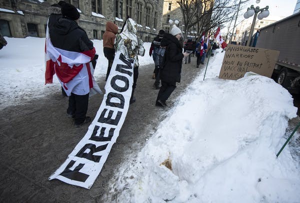 A person walks towards Parliament Hill for a rally against COVID-19 restrictions. (THE CANADIAN PRESS/Justin Tang Photo)