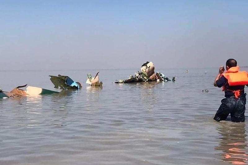 Recovery workers hold debris retrieved from a lake where a jet fighter crashed in the Sagaing region of Myanmar Wednesday, Feb. 16, 2022. The jet crashed into the lake Wednesday during a training flight in the country's northwest due to a malfunction, state-run media reported. (AP Photo)