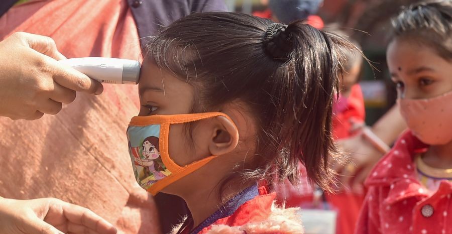Kolkata: A student undergoes thermal screening as she arrives to attend the first day of the class at 'Paray Sikshalaya', an outdoor learning initiative started by the West Bengal Government for students under VIII standard, in Kolkata, Monday, Feb. 7, 2022. (PTI Photo/Swapan Mahapatra)