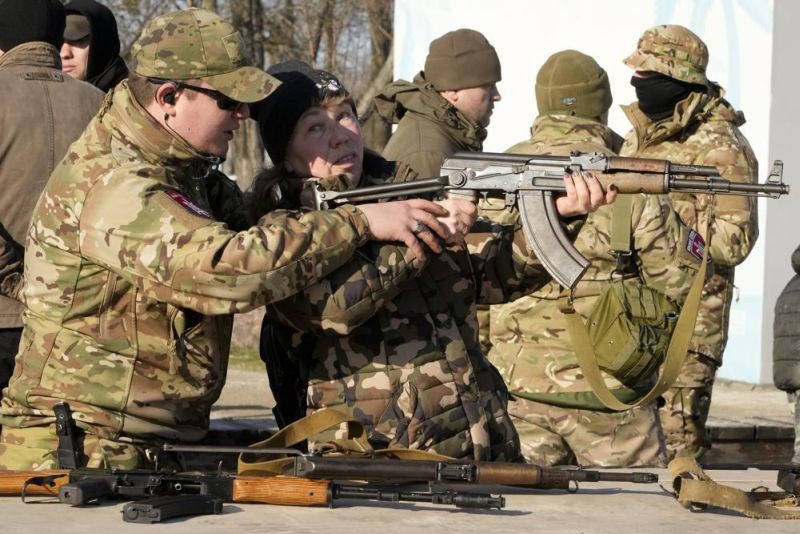 An instructor shows a woman how to use a Kalashnikov assault rifle, as members of a Ukrainian far-right group train, in Kyiv, Ukraine on February 13. (AP Photo)