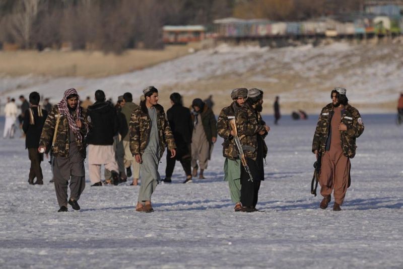 Taliban fighters walk at the frozen Qargha Lake, near Kabul, Afghanistan, in Kabul, Afghanistan, Friday, Feb. 11, 2022. The Taliban have detained two foreign journalists on assignment with the U.N. refugee agency and a number of its Afghan staff working in the country's capital, UNHCR said Friday. (AP Photo)
