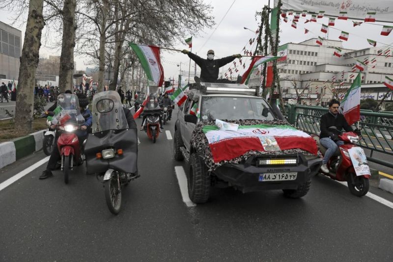 People parade with Iran's flags during the annual rally commemorating anniversary of1979 Islamic Revolution in Azadi (freedom) Sqaure in Tehran, Iran, Friday, Feb. 11, 2022. Thousands of cars and motorbikes paraded in the celebration, although fewer pedestrians were out for a second straight year due to concerns over the coronavirus pandemic. (AP Photo)