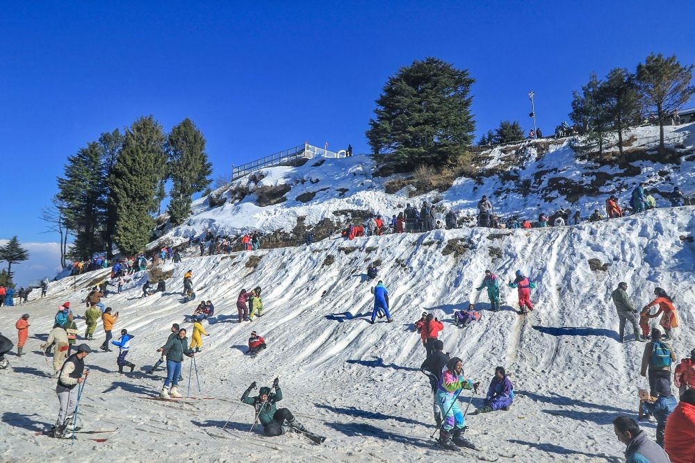 Shimla: Tourists ski down a slope, in the snow, during winter season at Kufri, in Shimla, Sunday, Feb. 20, 2022. (PTI Photo)(
