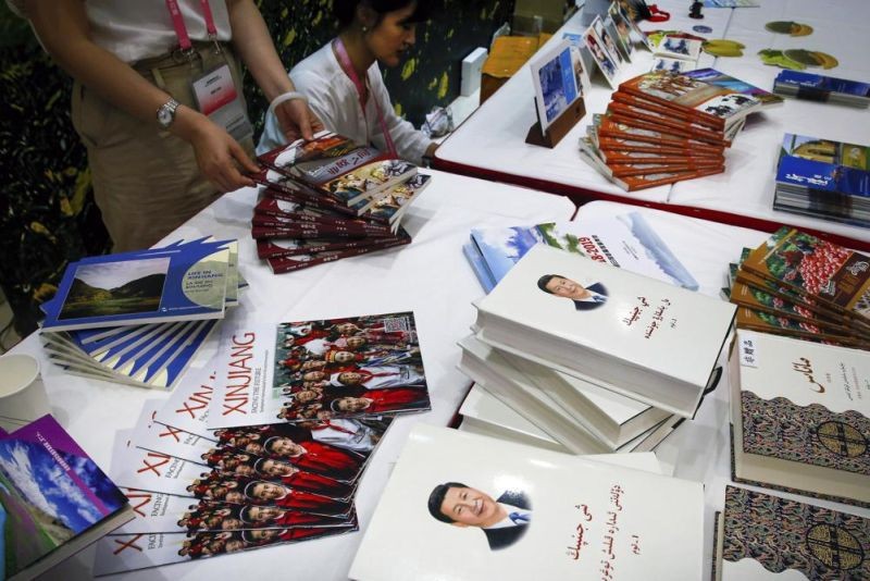 Copies of the book on the governance of Chinese President Xi Jinping are displayed with booklets promoting Xinjiang during a news conference by Shohrat Zakir, chairman of China's Xinjiang Uighur Autonomous Region, at the State Council Information Office in Beijing on July 30, 2019. As the Chinese government tightened its grip over its ethnic Uyghur population, it sentenced one man to death and three others to life in prison in 2021 for textbooks drawn in part from historical resistance movements that had once been sanctioned by the ruling Communist Party. (AP File Photo)