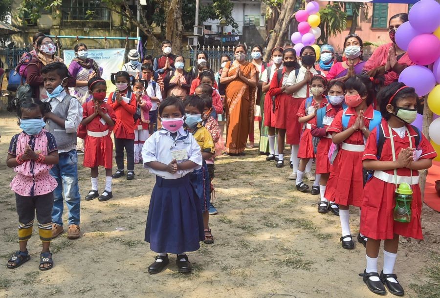 Kolkata: Nursery students wearing face masks pray with their teachers during the first day of the class at 'Paray Sikshalaya', an outdoor learning initiative started by the West Bengal Government for students under VIII standard, in Kolkata, Monday, Feb. 7, 2022. (PTI Photo/Swapan Mahapatra)