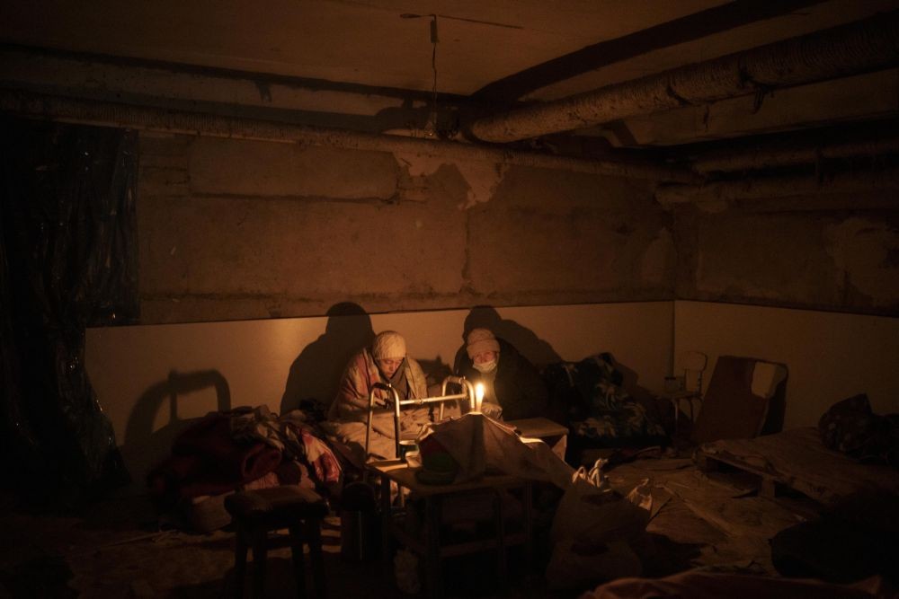 Kyiv : Two elderly woman lit by a candle hide in a basement used as a bomb shelter in Irpin, outskirts of Kyiv, Ukraine, Sunday, March 13, 2022. AP/PTI