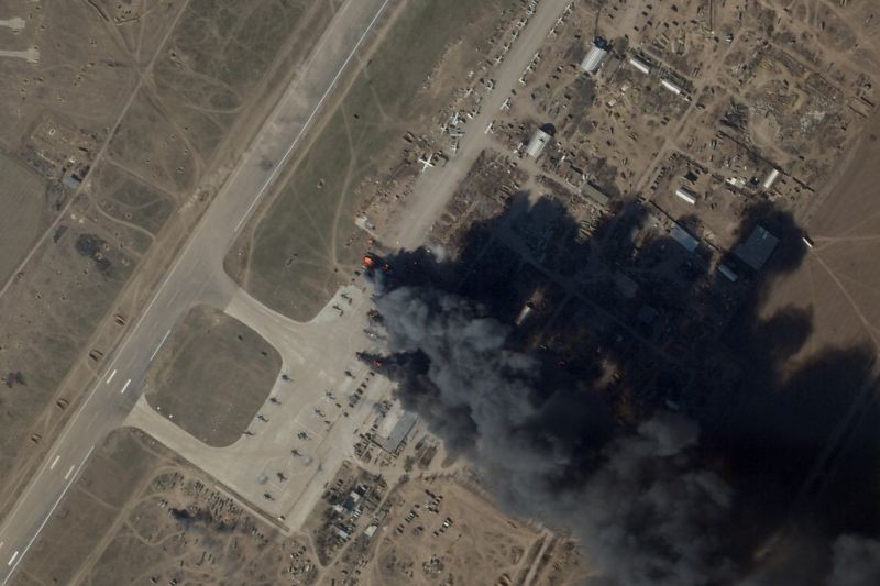 In this satellite picture provided by Planet Labs PBC, fire and smoke is seen at Kherson International Airport and Air Base in Kherson, Ukraine on March 15. A suspected Ukrainian strike on the air base damaged Russian helicopters and vehicles Tuesday. (AP/PTI Photo)