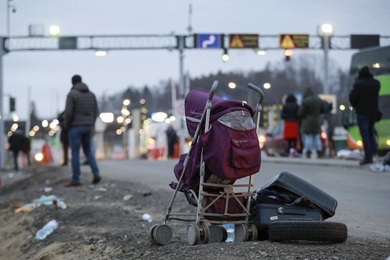 Deserted suitcase and a baby cart are left beside the road as Ukrainian refugees flee Russian invasion at a border crossing in Medyka, Poland, on Wednesday, March 2, 2022. The U.N. refugee agency said Tuesday that about 660,000 people have fled Ukraine for neighboring countries since the Russian invasion began.(AP Photo)