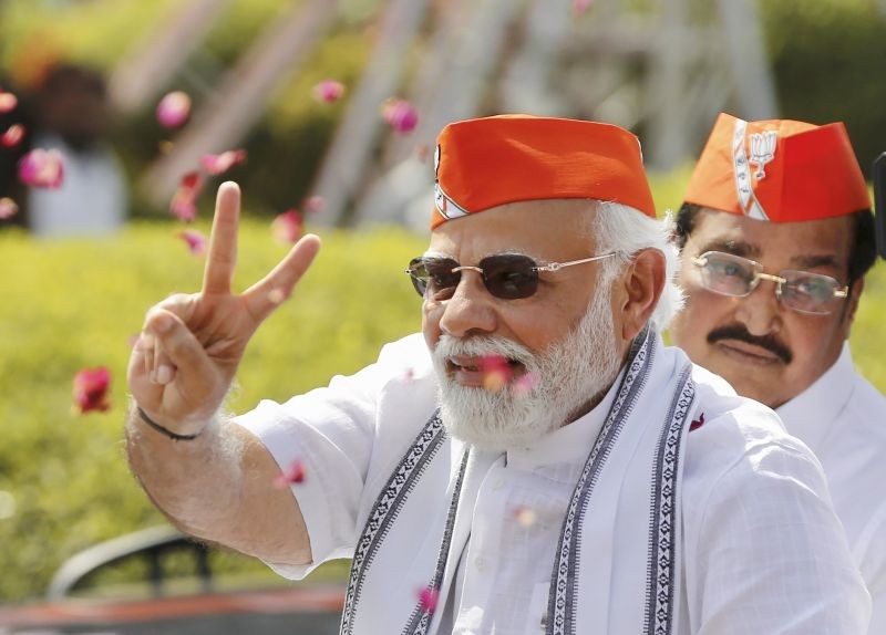 Prime Minister Narendra Modi flashes the victory sign during a roadshow after BJP's victory in the recent Assembly polls, in Ahmedabad on March 11, 2022. (PTI Photo)