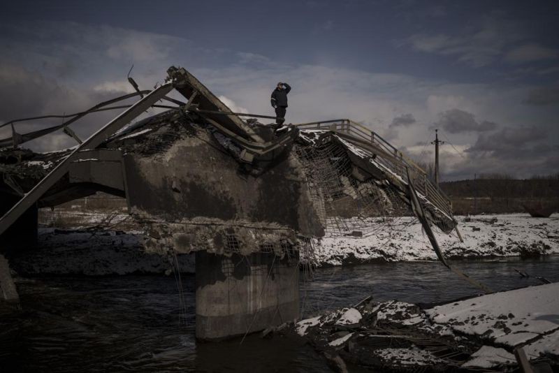A man stands atop a destroyed bridge in Irpin, on the outskirts of Kyiv, Ukraine, Tuesday, March 8, 2022. (AP Photo)