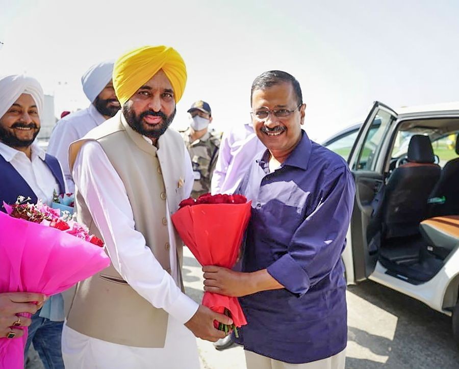 Amritsar: Punjab CM-designate Bhagwant Mann receives AAP national convenor Arvind Kejriwal at Amritsar airport. (PTI Photo)(