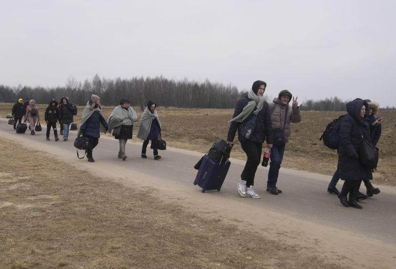 A group of people, who fled with others from Ukraine, walks on a road at the border crossing in Budomierz, Poland on March 7, 2022. Russia's invasion of Ukraine has set off the largest mass migration in Europe in decades, with more than 1.5 million people having crossed from Ukraine into neighboring countries. (AP/PTI Photo)
