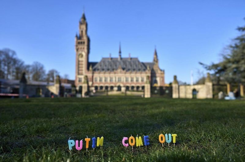 Candles are set in the grass with the text 'Putin Come Out' in front of the International Criminal Court in The Hague, Netherlands, Monday, March 7, 2022. A representative for Kyiv has urged the United Nations' top court to order Russia to halt its devastating invasion of Ukraine, at a hearing snubbed by Russia. (AP Photo)